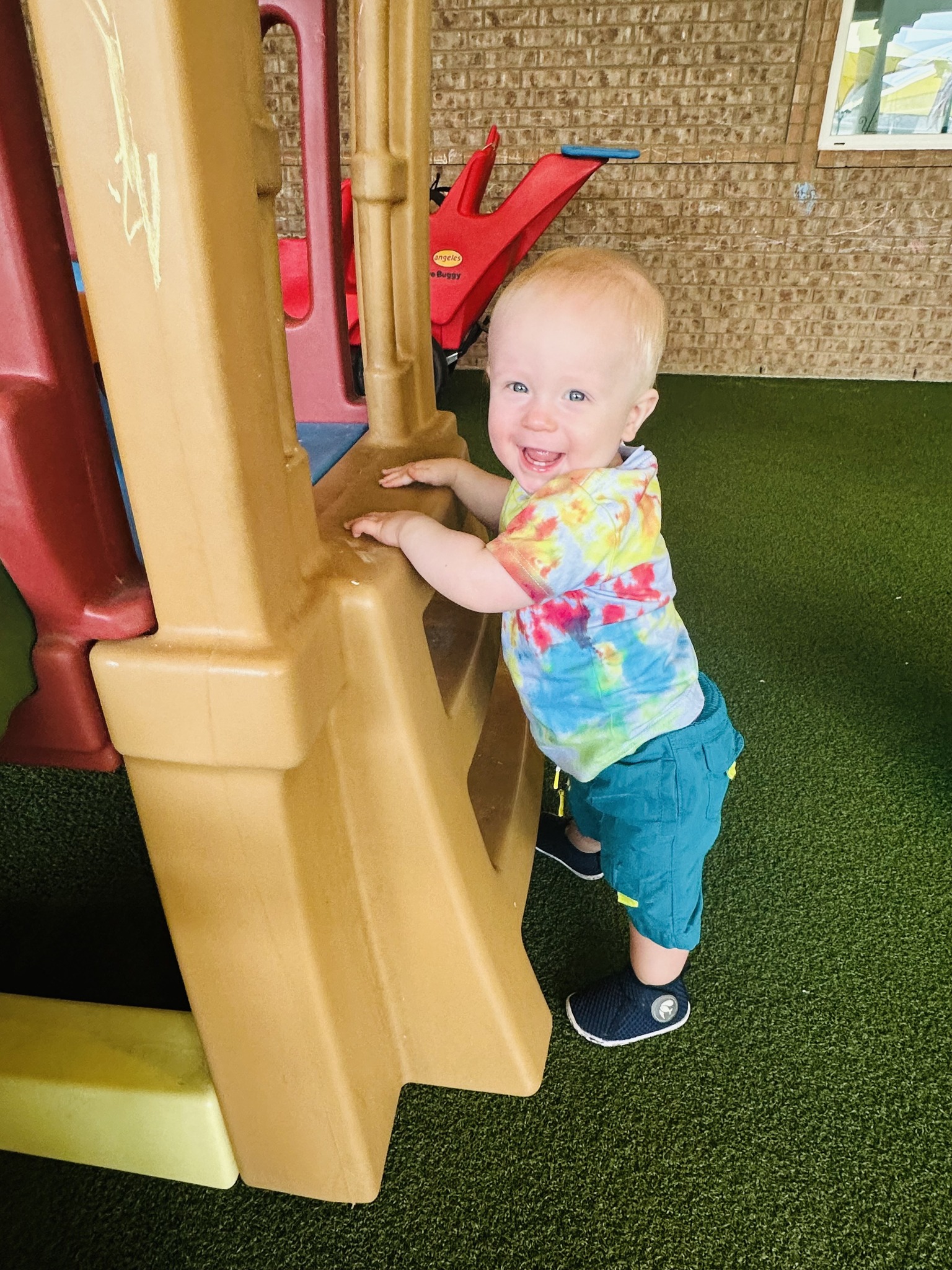 Child standing and holding onto a play structure