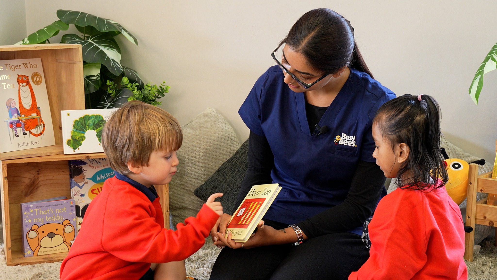 Person reading a book to two children