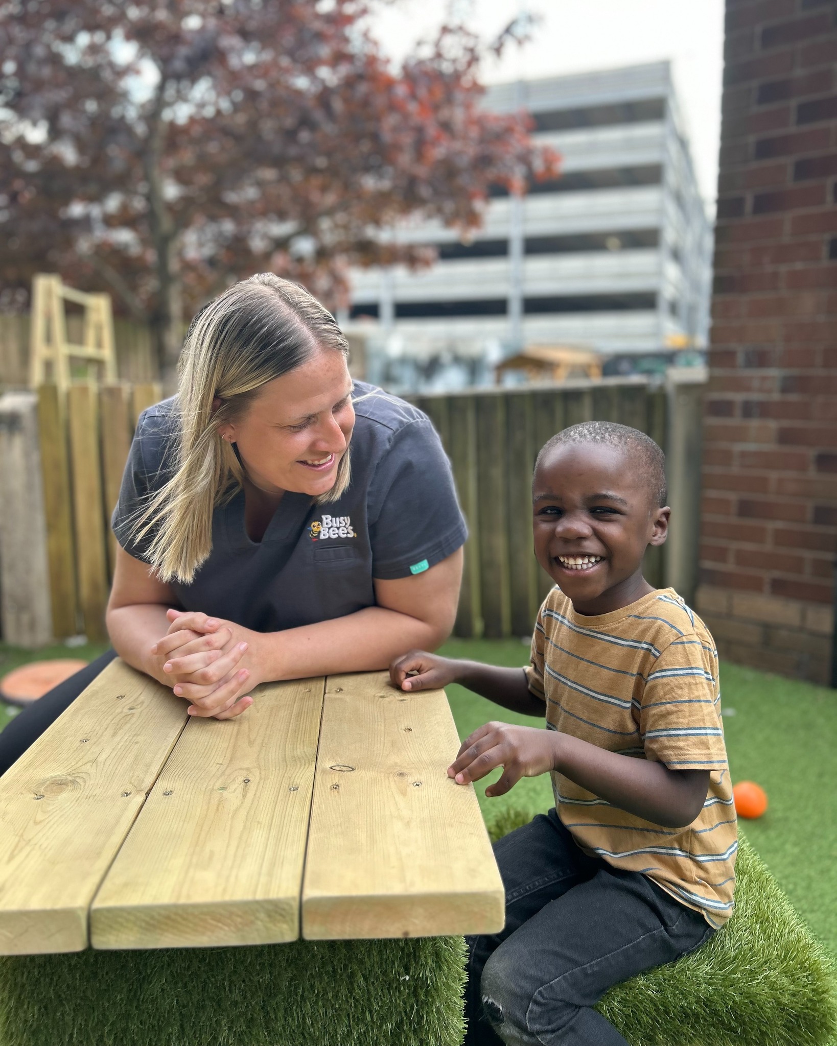 Person and child sitting at a picnic table outdoors