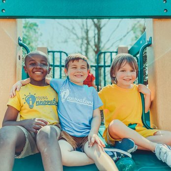Three children sitting together on a playground structure