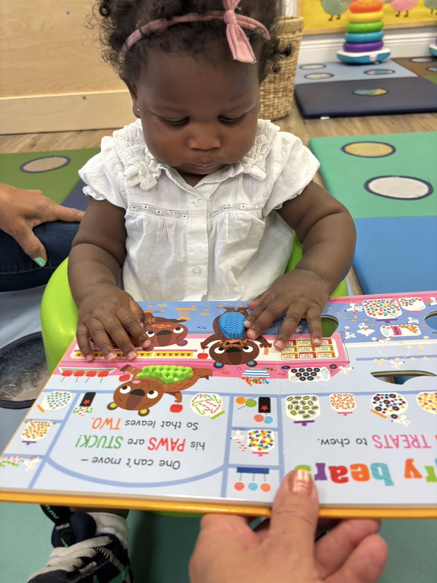 Child looking at and touching an interactive book in a room