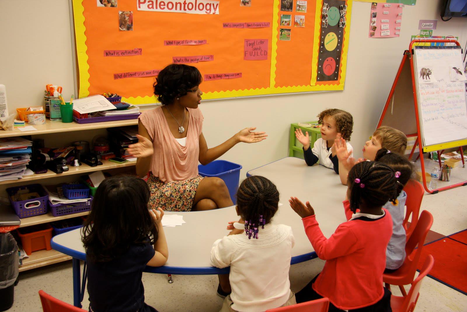 Person speaking to children in a classroom