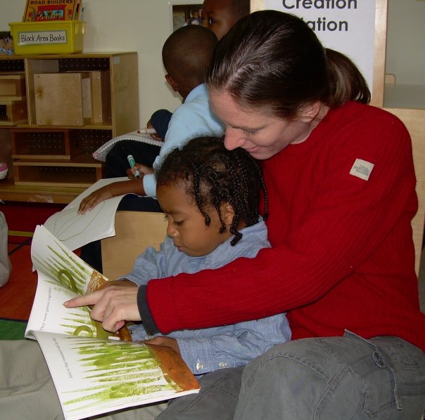 Person and child reading a book together