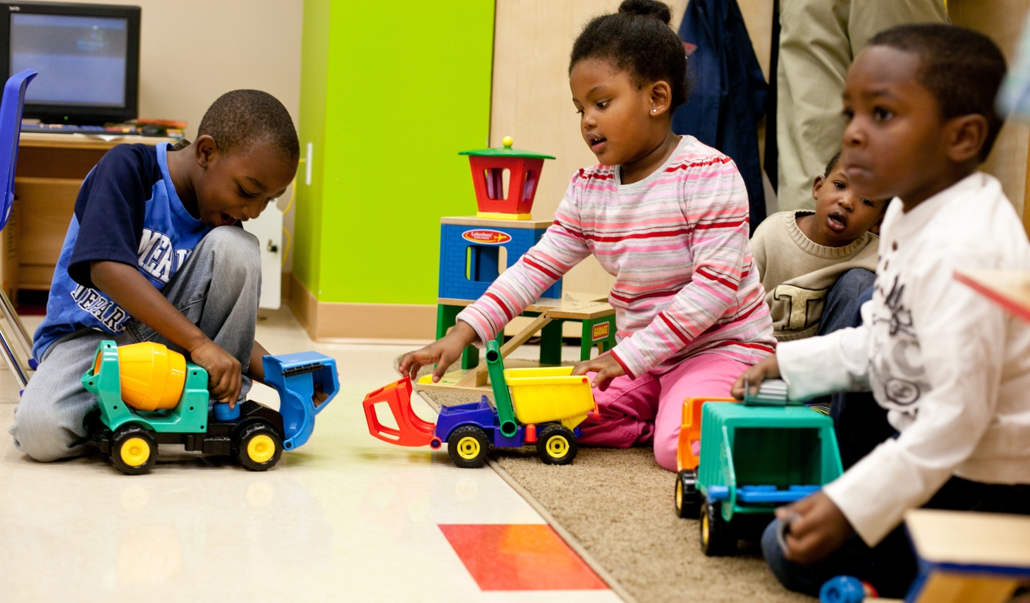 Children playing with toy trucks on the floor