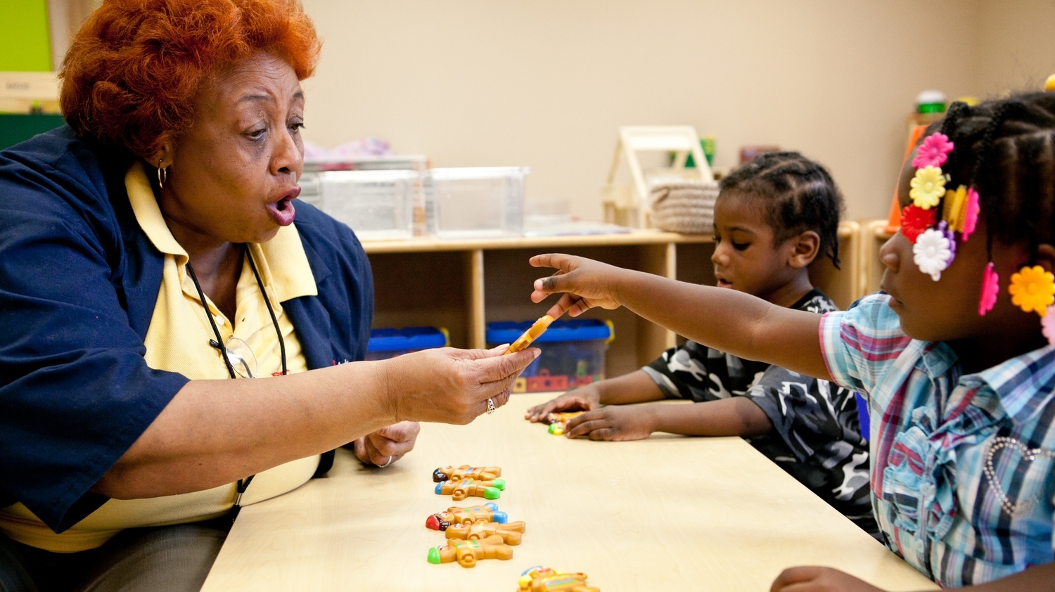 Adult and child playing with counting toys at a table