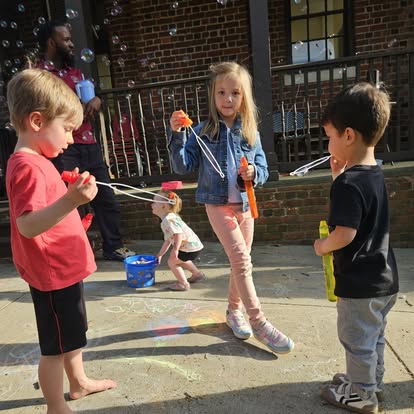 Children playing with bubble wands outdoors
