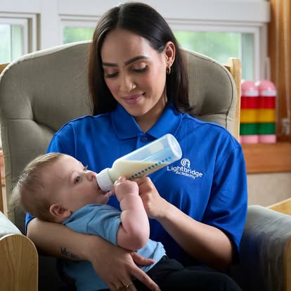 Person feeding a child with a bottle