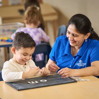Adult and child learning letters at a table