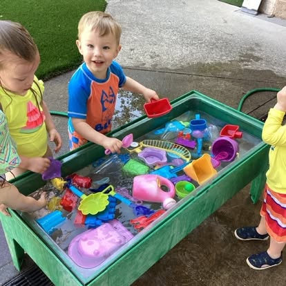 Children playing with toys in a water table