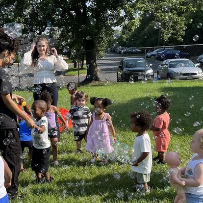Adults and children playing with bubbles outdoors