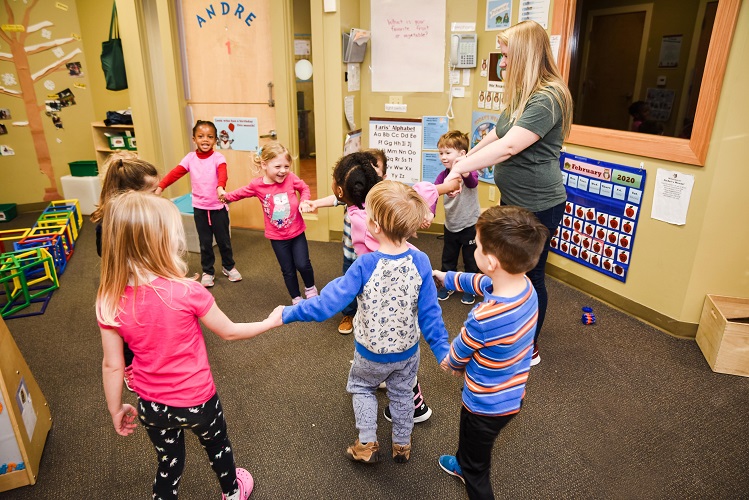 Adult and children holding hands in a circle