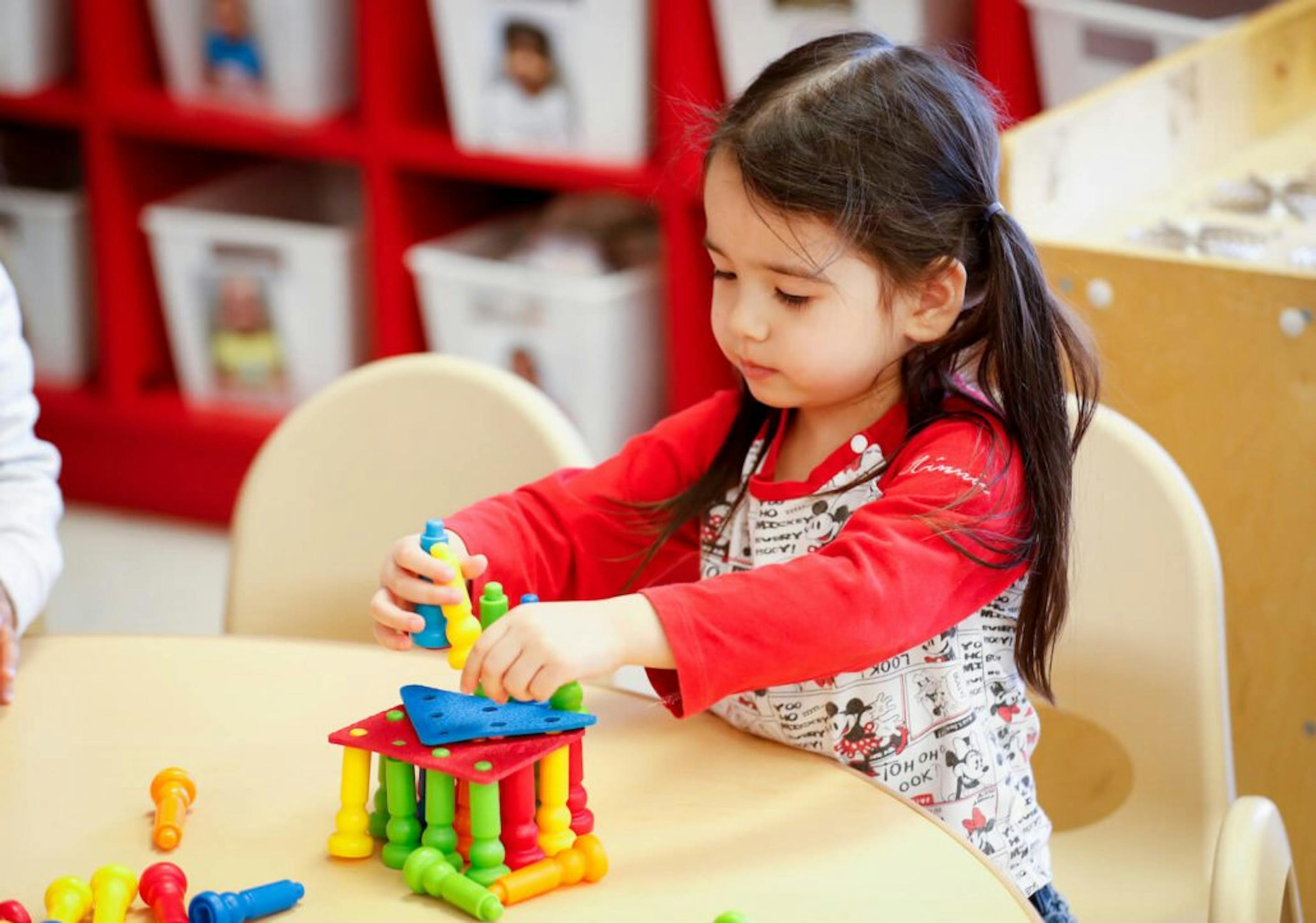 Child playing with colorful building blocks at a table