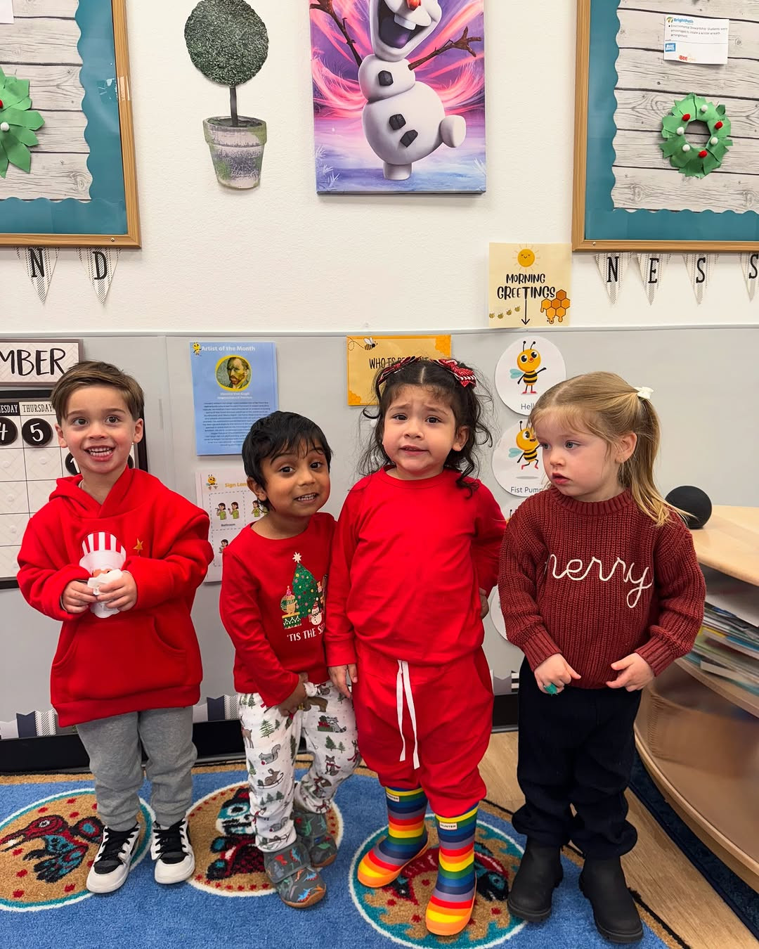 Four children standing in a classroom