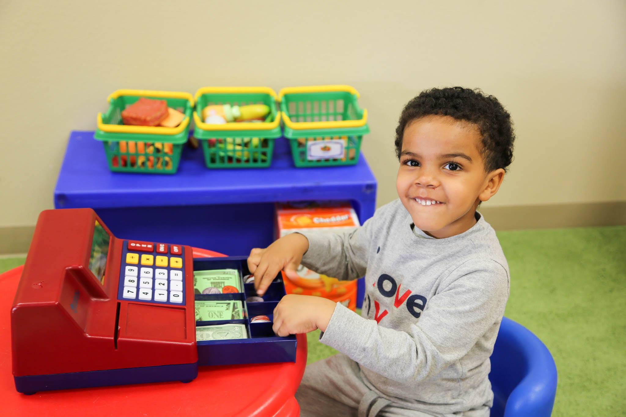 Child playing with a toy cash register