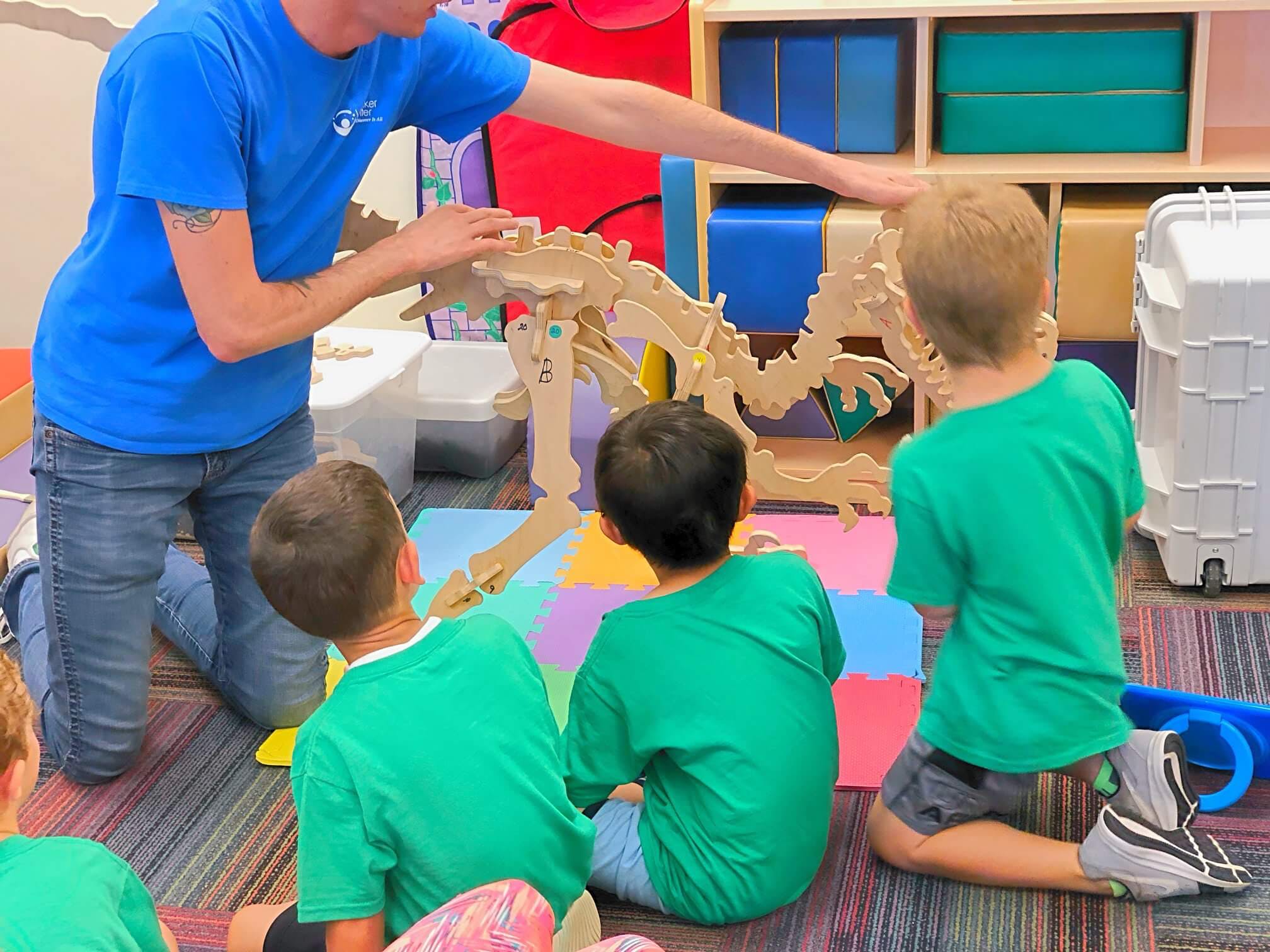 Person and children interacting with a dinosaur skeleton model