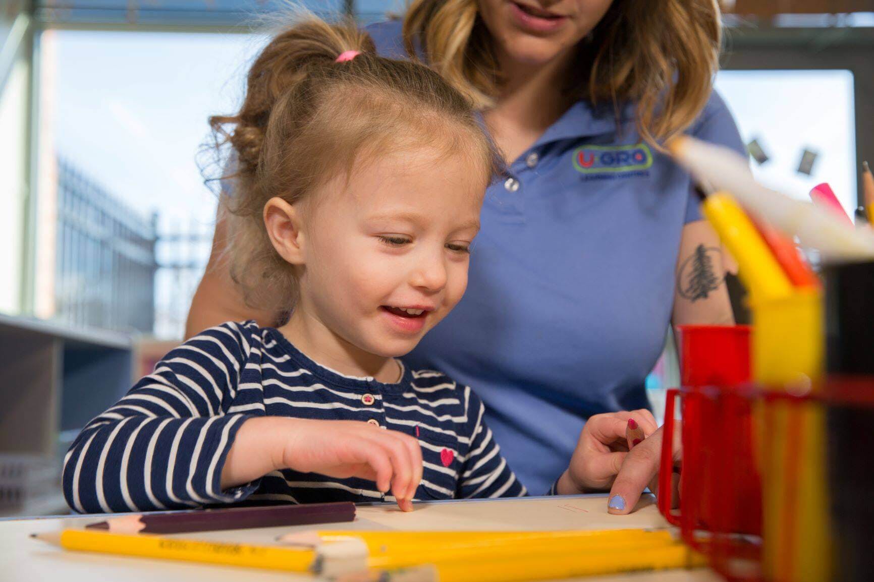 Adult and child looking at pencils on a table