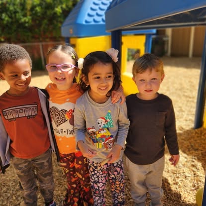 Four children standing together on a playground