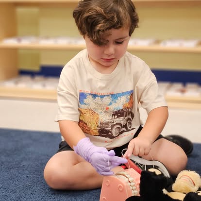 Child wearing a glove and working with a dental model