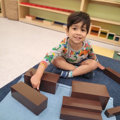 Child playing with brown blocks on a mat