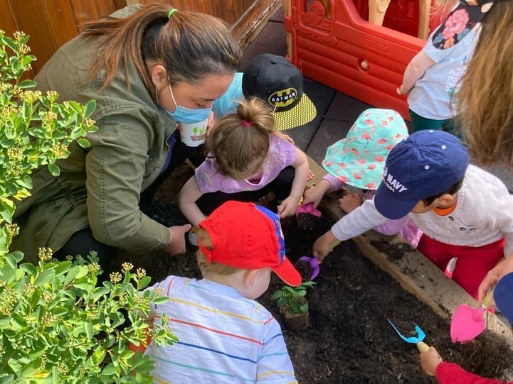 Adult and children planting in a garden