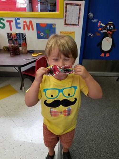 Child holding a colorful craft to their face