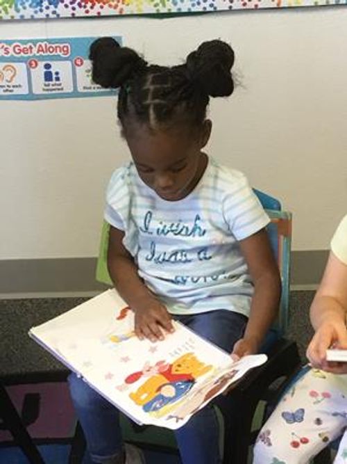Child sitting and looking at a book
