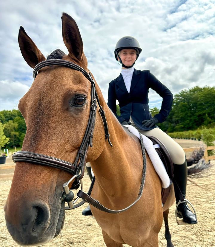 Child in riding helmet and jacket on a horse