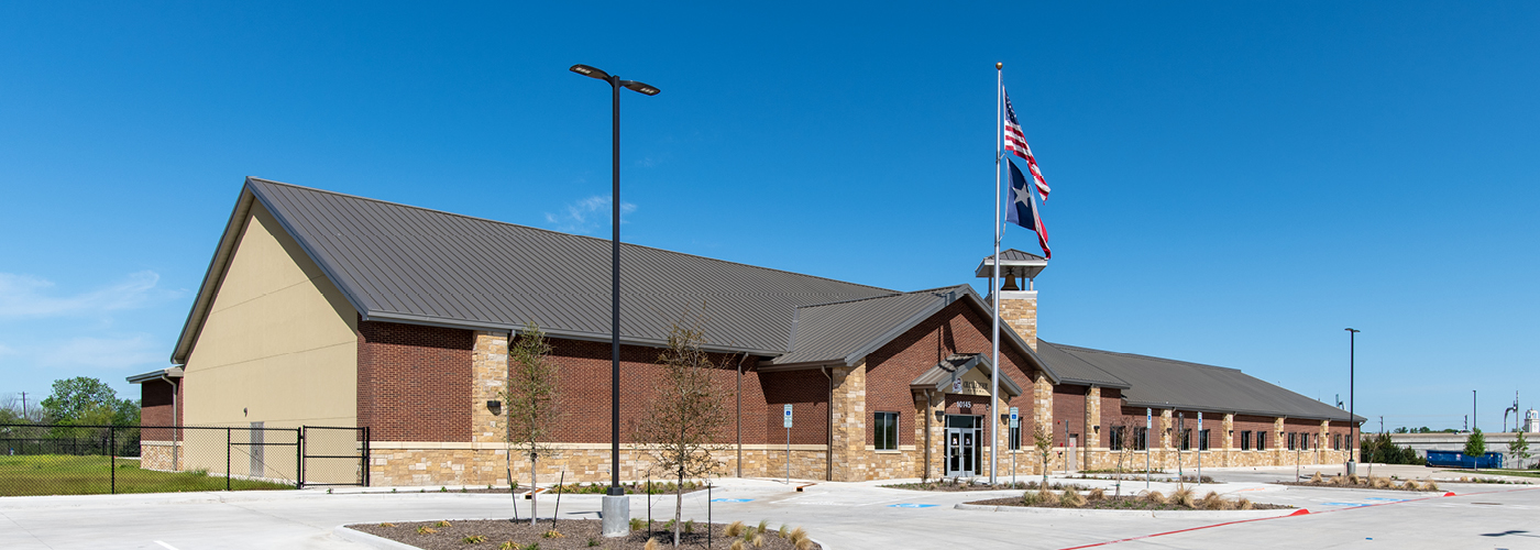Building with a brown roof and stone facade under a clear blue sky