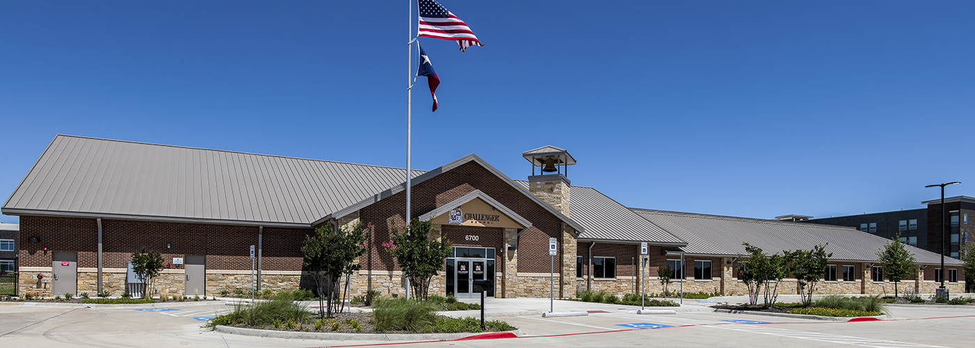 Building with a flagpole flying two flags in front