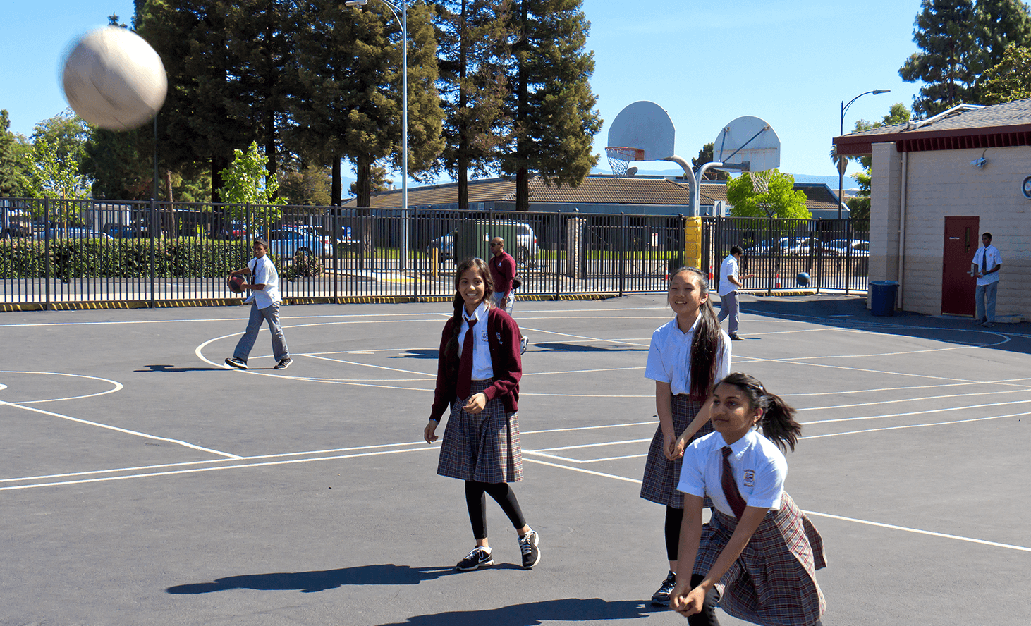 Children playing with a ball on a paved court