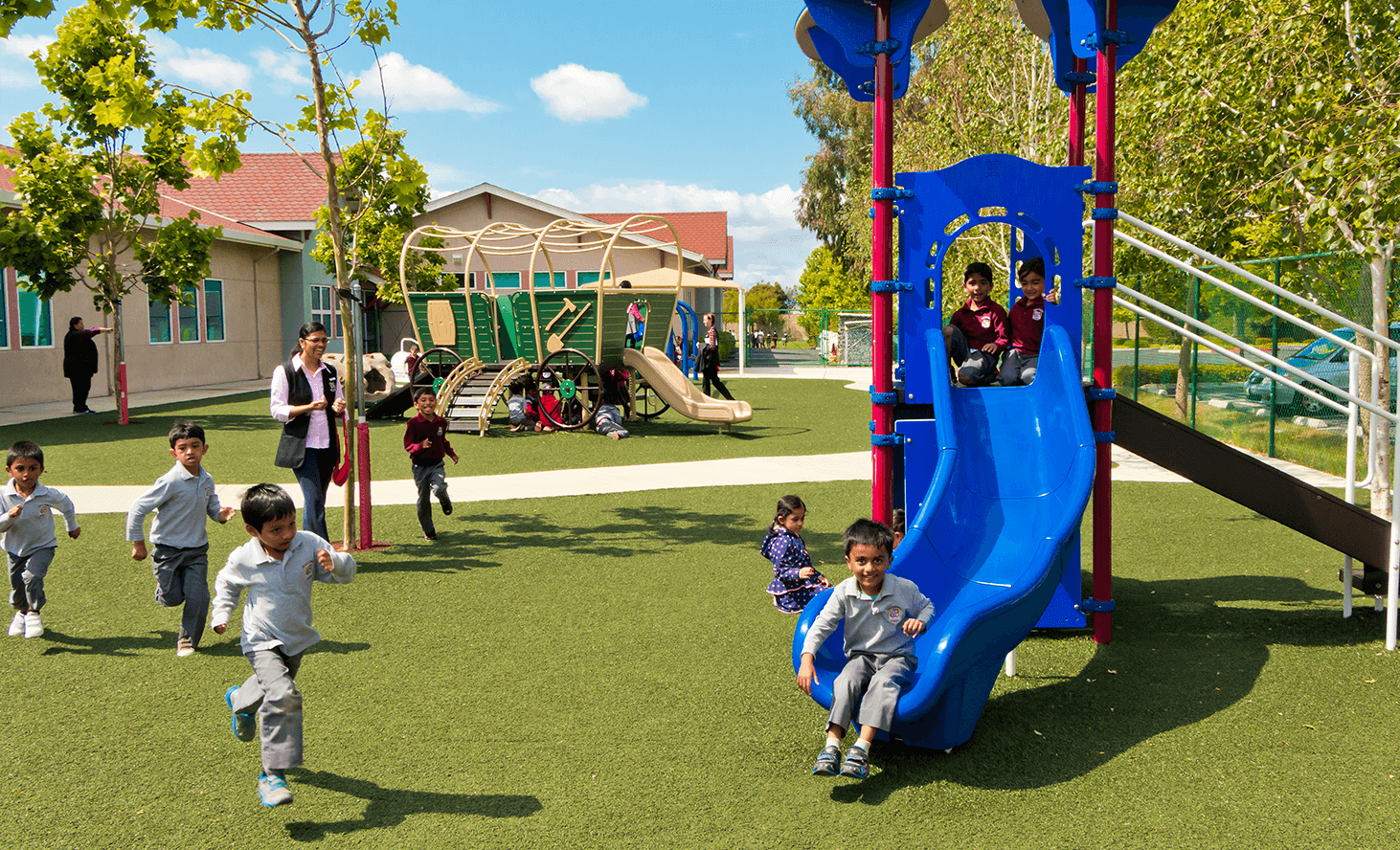 Children playing on a playground with slides and climbing structures
