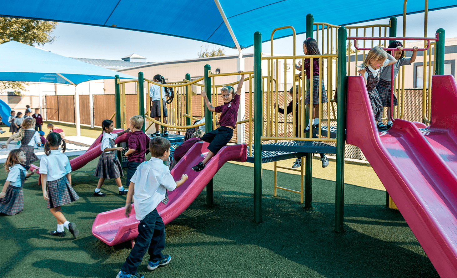 Children playing on a playground with slides and climbing structures