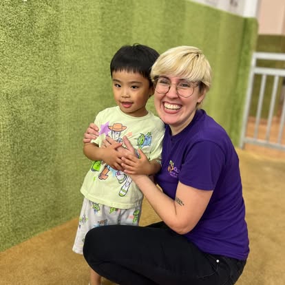 Person kneeling next to a child