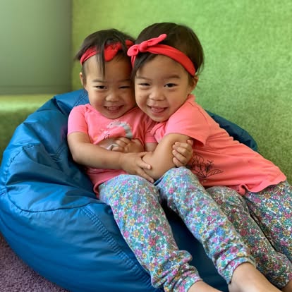 Two children sitting together on a beanbag