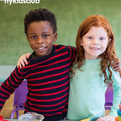 Two children standing together, one with arm around the other