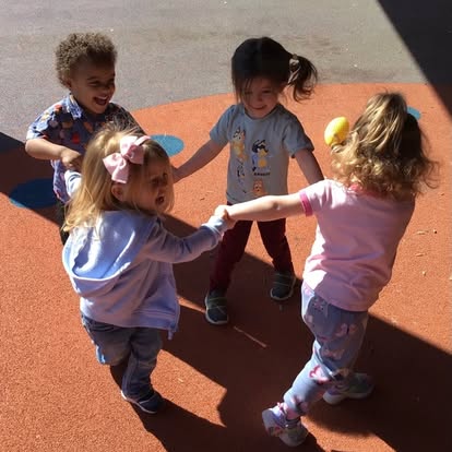 Four children holding hands in a circle