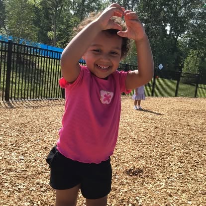 Child making a heart shape with hands
