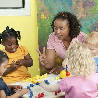 Adult and children at a table with colorful blocks
