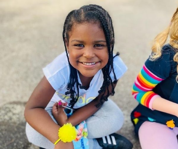 Child with braided hair smiling