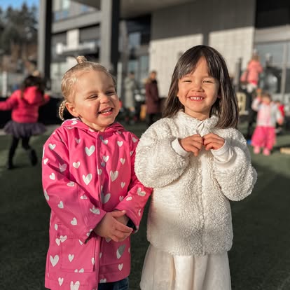 Two children smiling outdoors