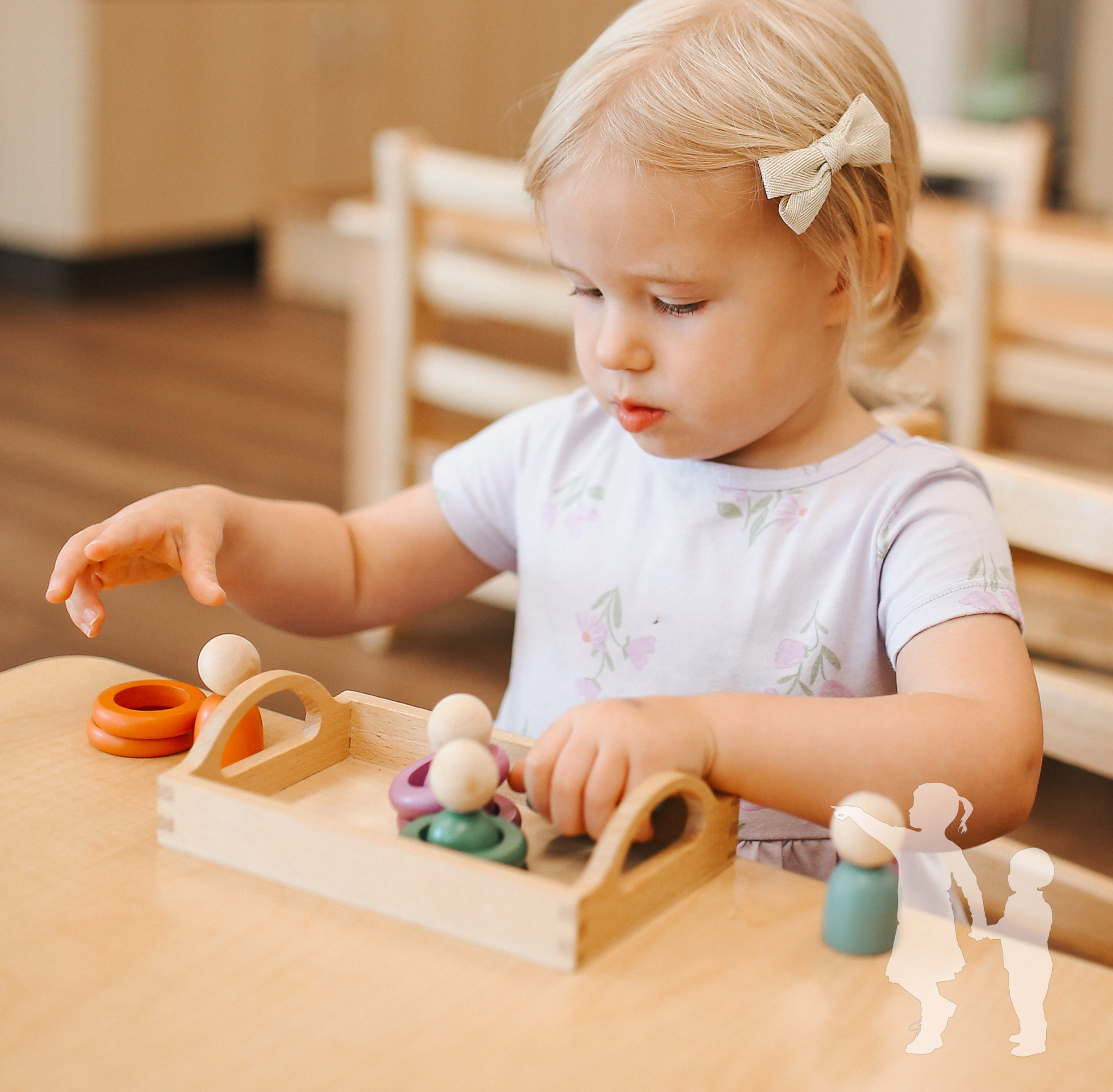 Child playing with wooden toys on a table in a classroom
