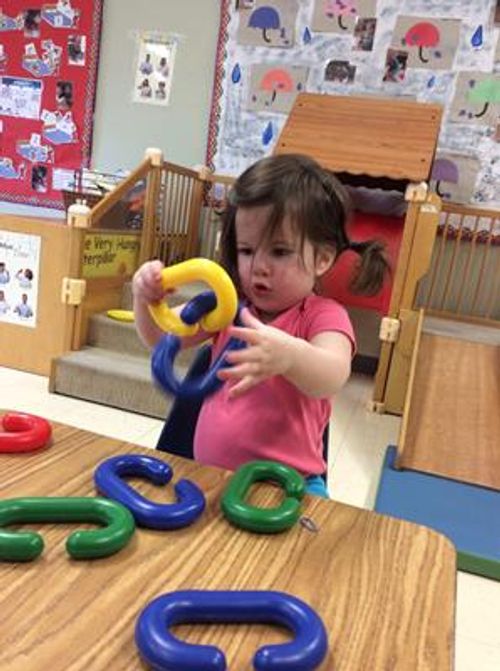 Child playing with colorful plastic links
