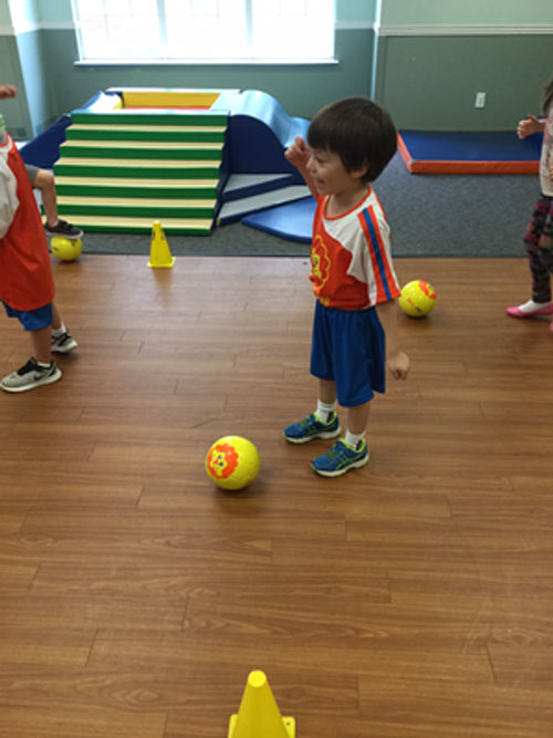 Child in a classroom with balls and soft play equipment
