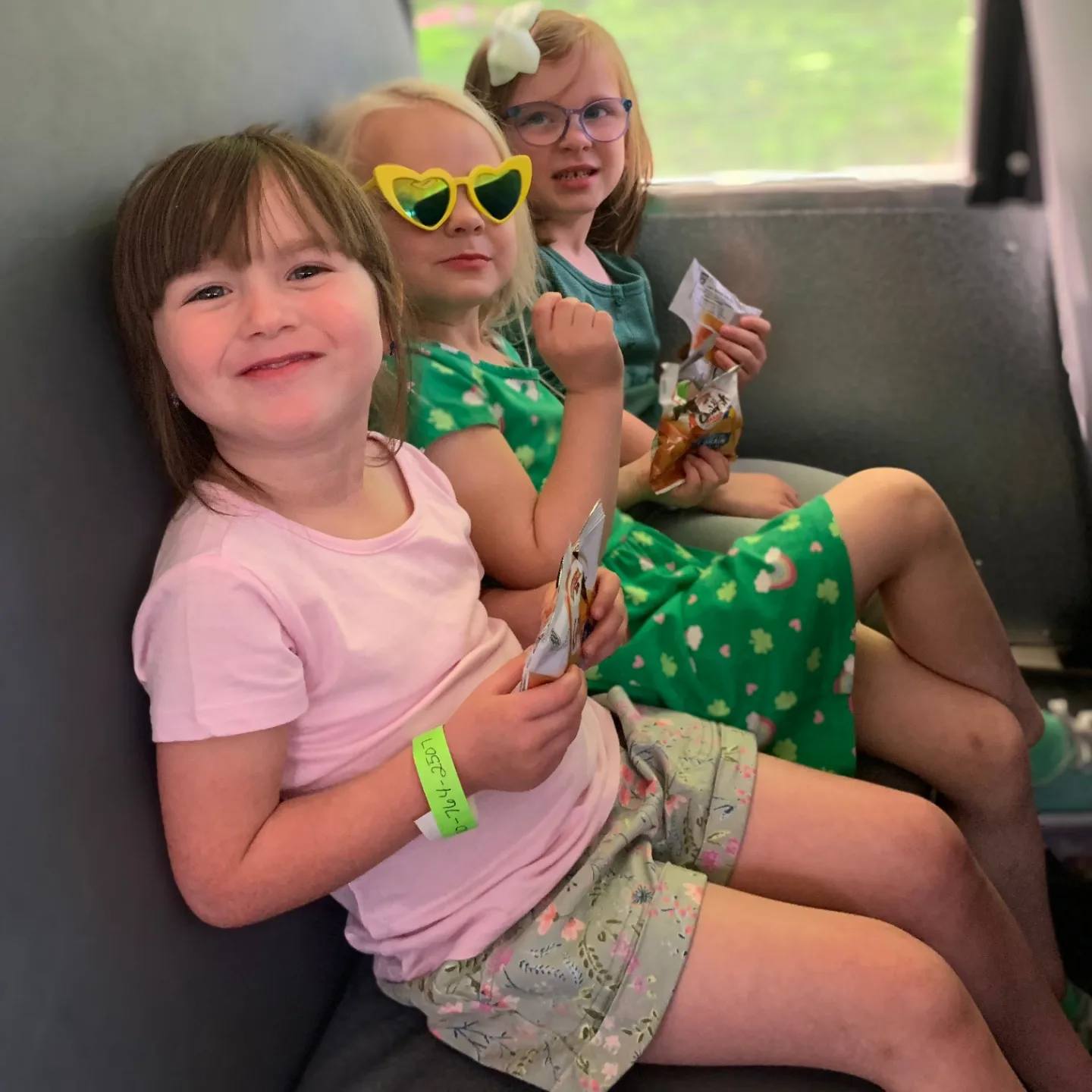Three children sitting on a bus seat