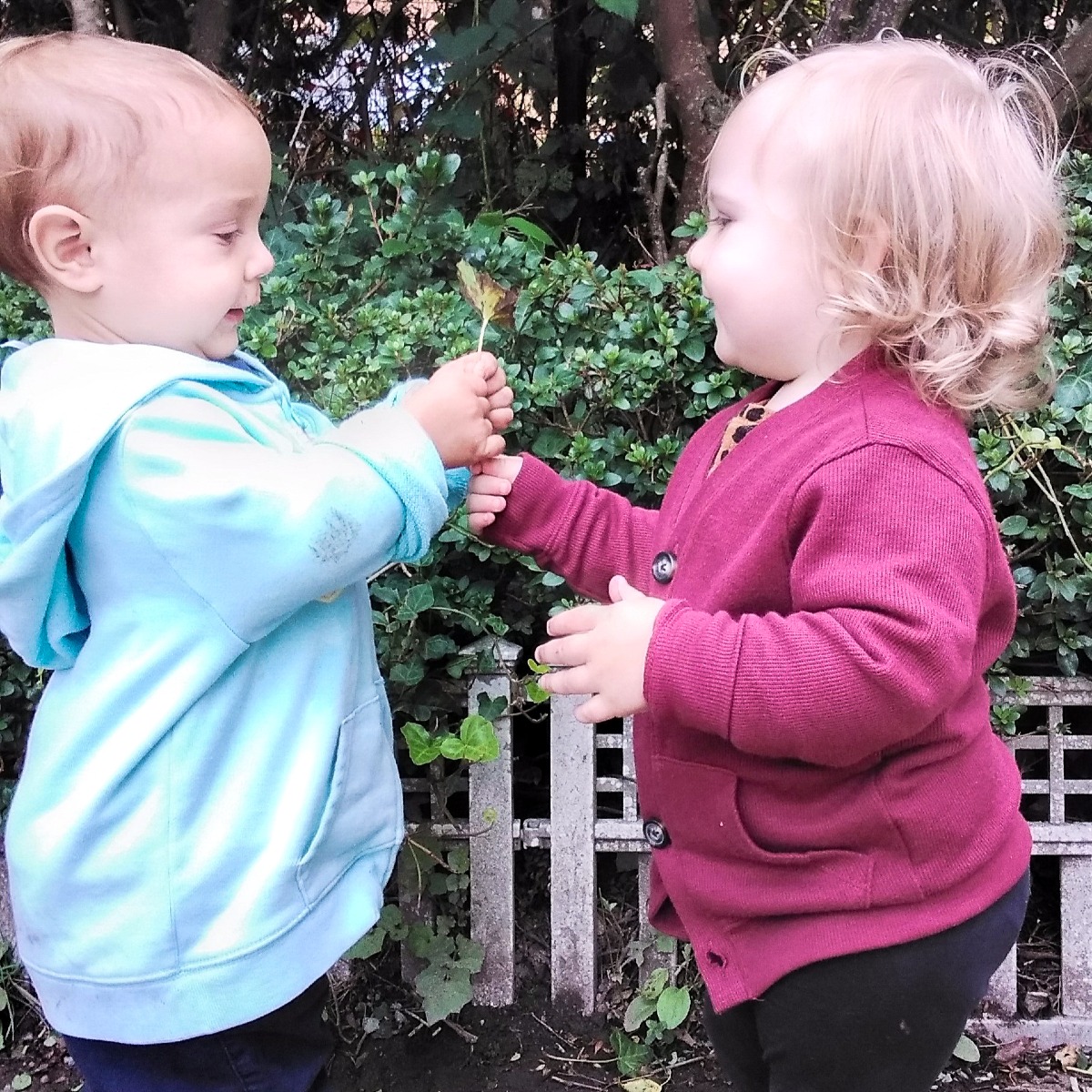 Two children holding a lollipop together