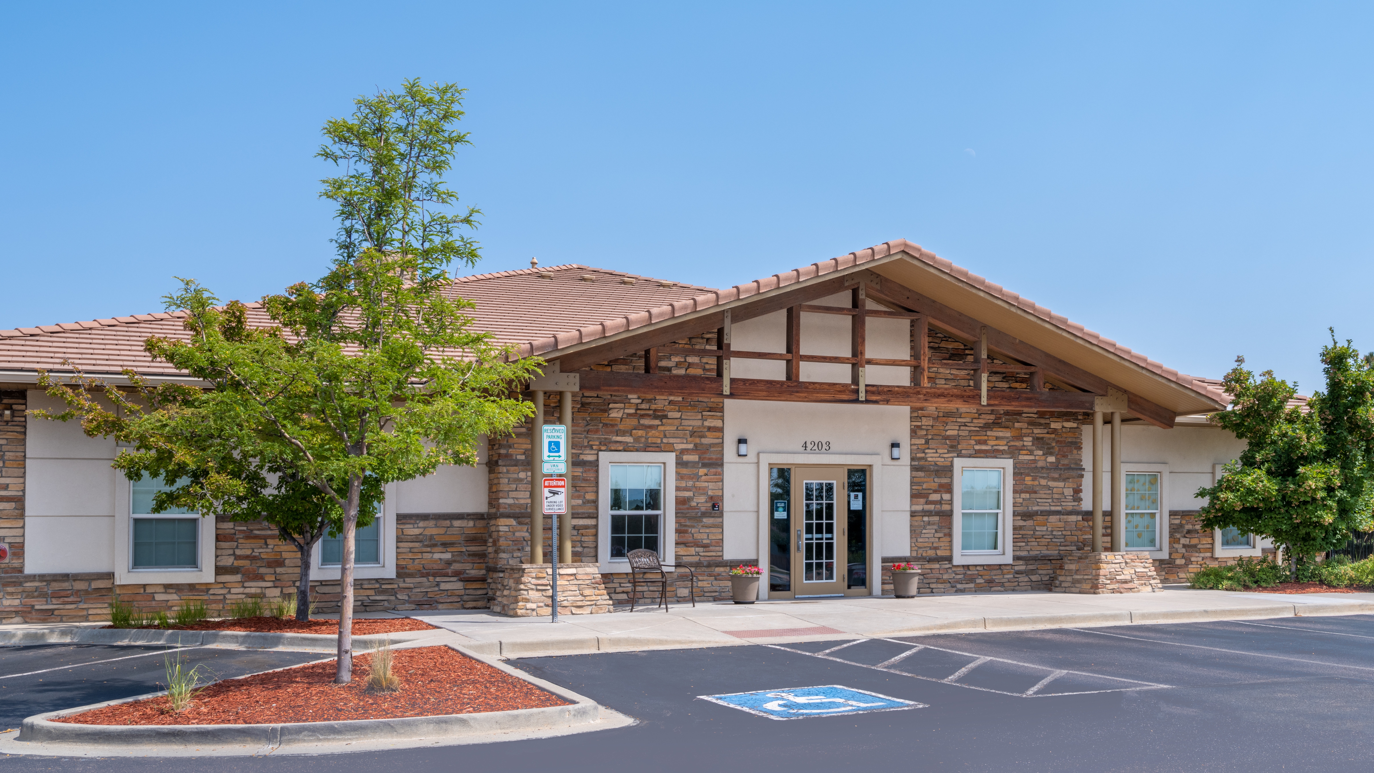 Building exterior with stone facade and parking lot
