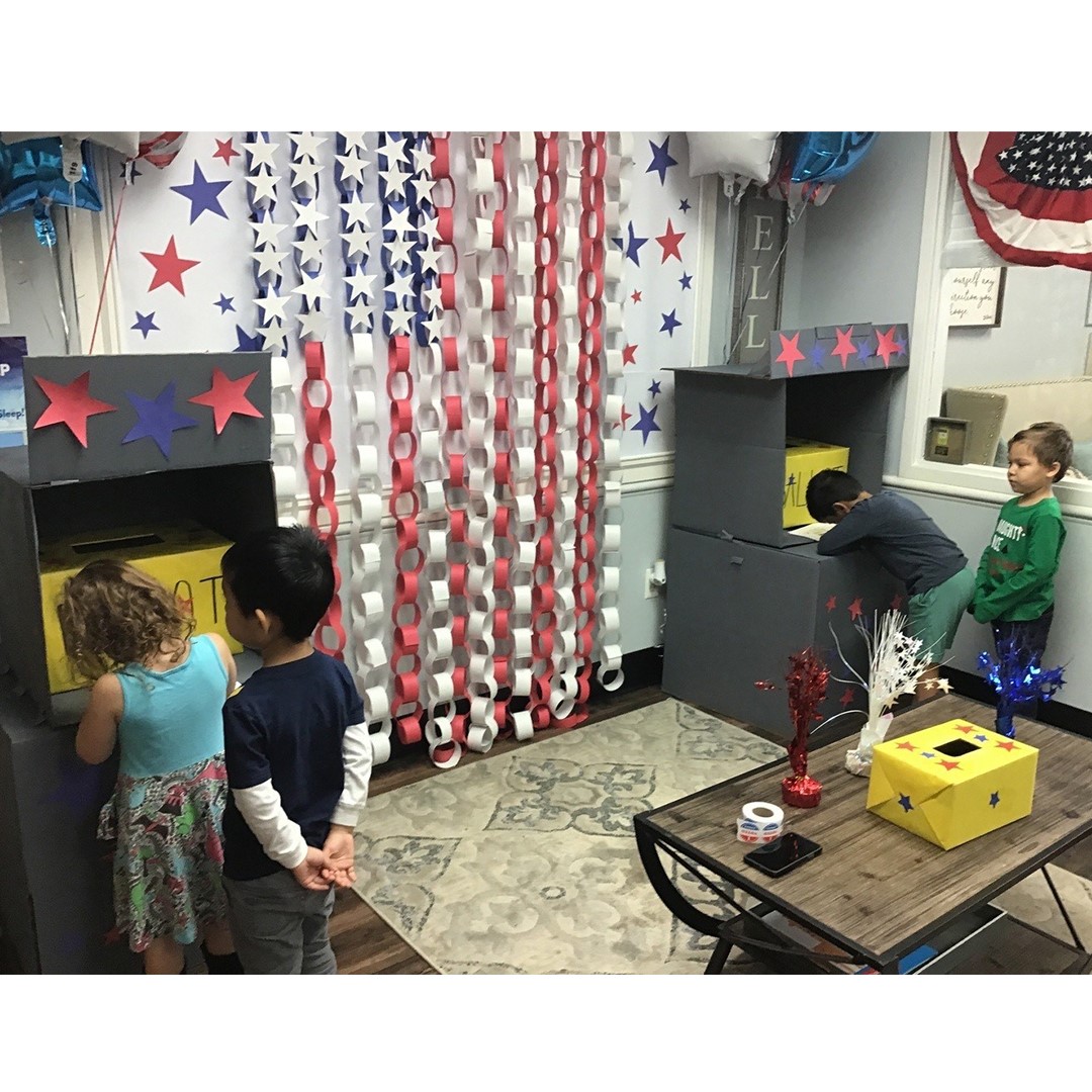 Children playing with boxes in a room decorated with stars and paper chains