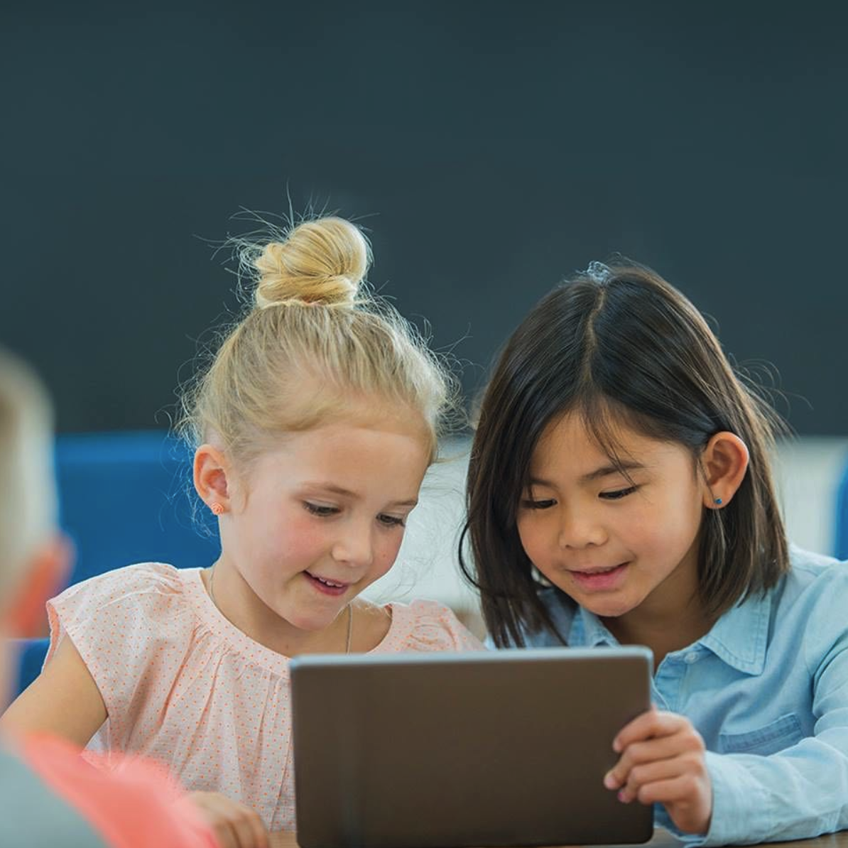 Two children looking at a tablet