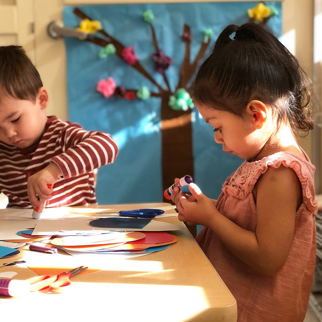 Two children doing crafts at a table