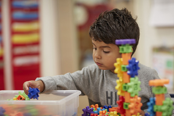 Child playing with colorful interlocking toys